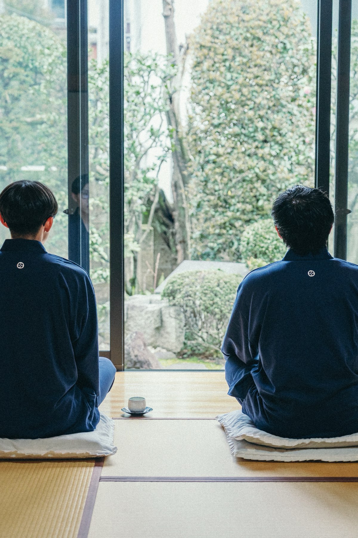 庭を望む座敷で、並んで坐禅する二人