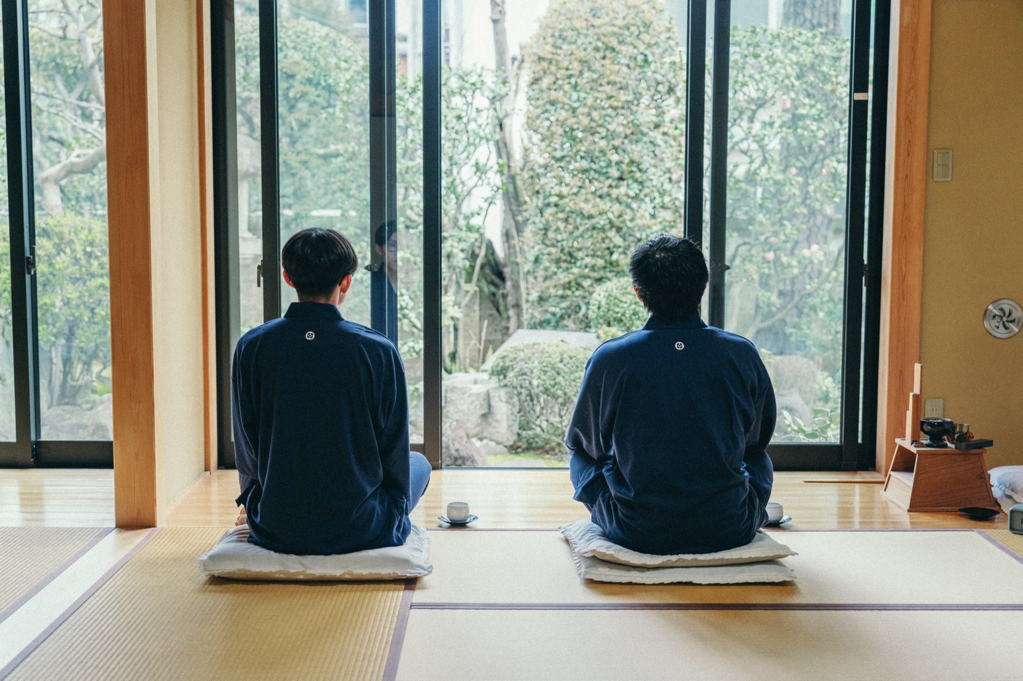 庭を望む座敷で、並んで坐禅する二人